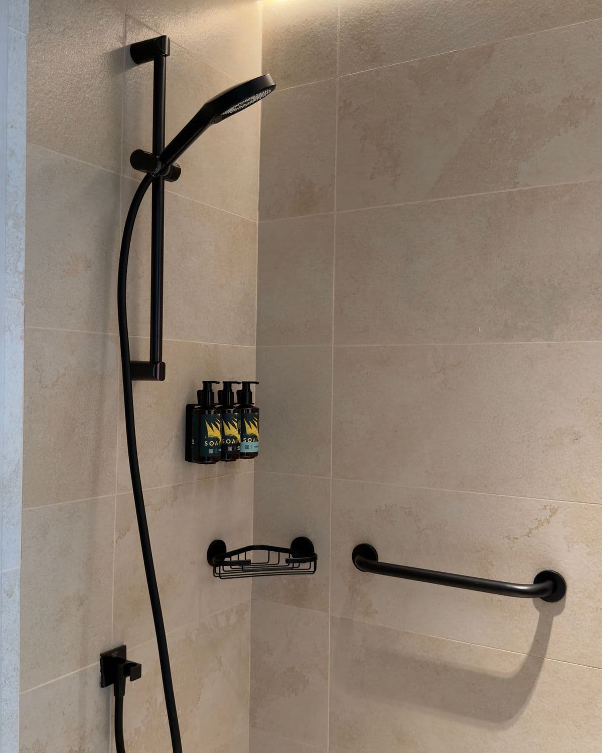 A warm, large-format tiled shower with clean edges and minimal grout lines.